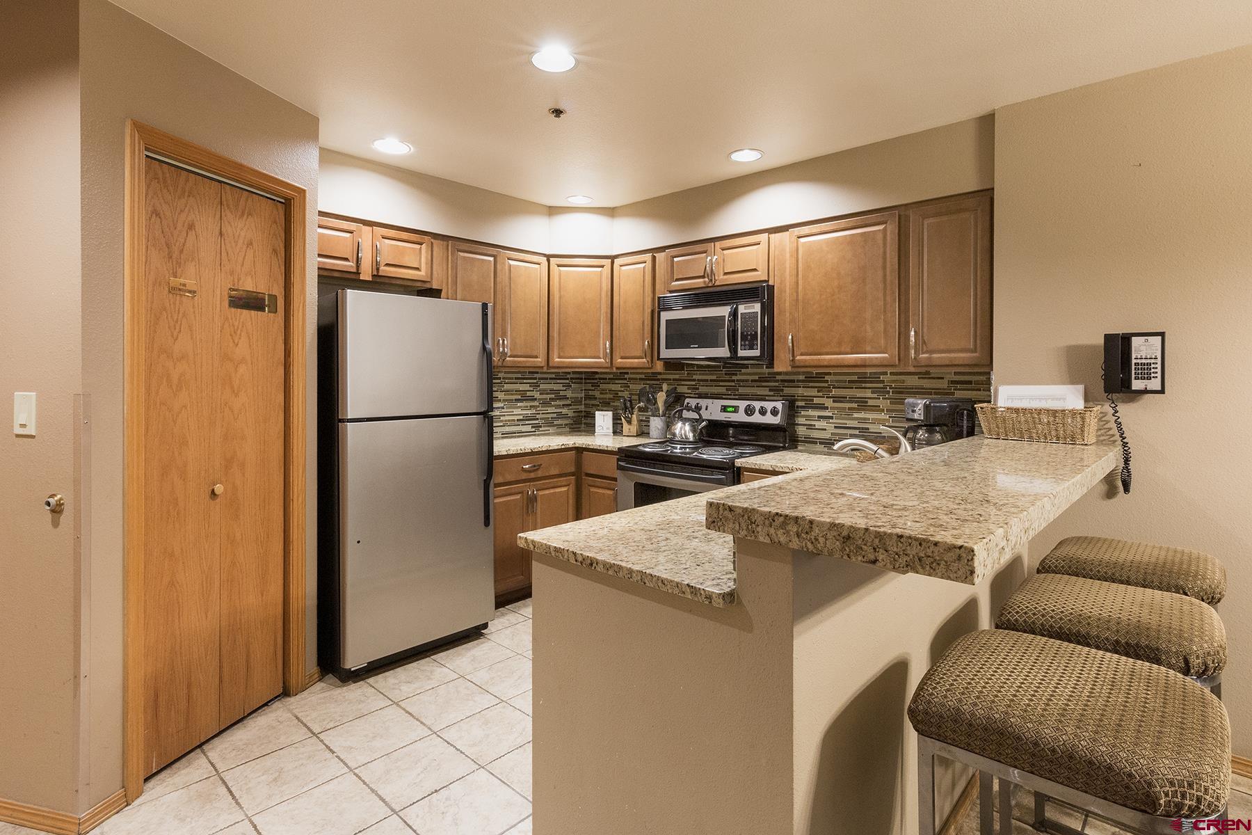 71 Needles Way, Unit 443 Durango, CO 81301 - Photo 6 of 26 a kitchen with kitchen island a counter top space cabinets and stainless steel appliances
