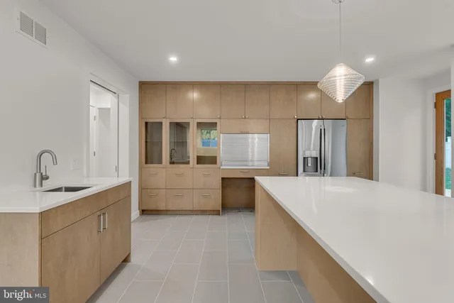 a large white kitchen with a large window