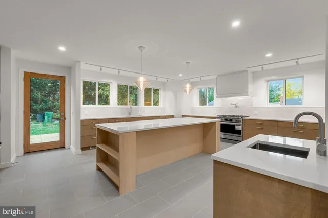 a kitchen with stainless steel appliances granite countertop a stove a sink and a refrigerator