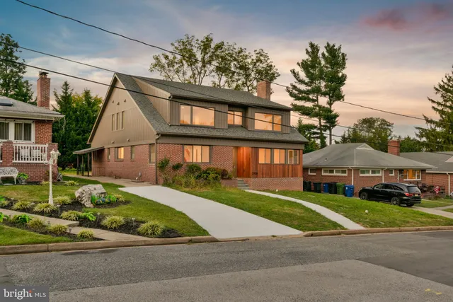 a front view of a house with a yard and potted plants