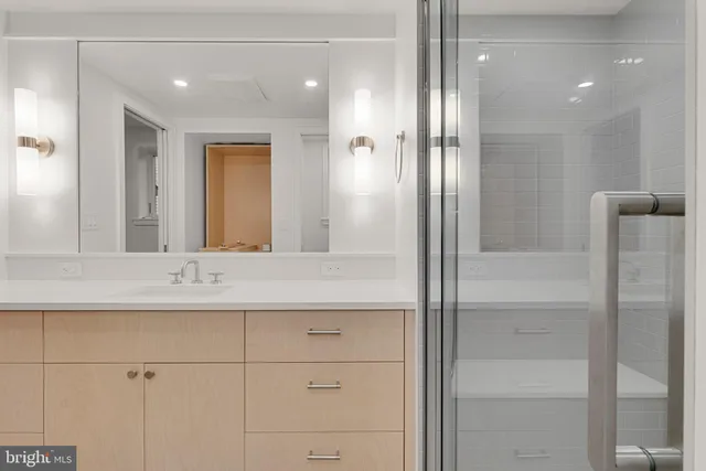 a bathroom with a shower sink vanity and mirror