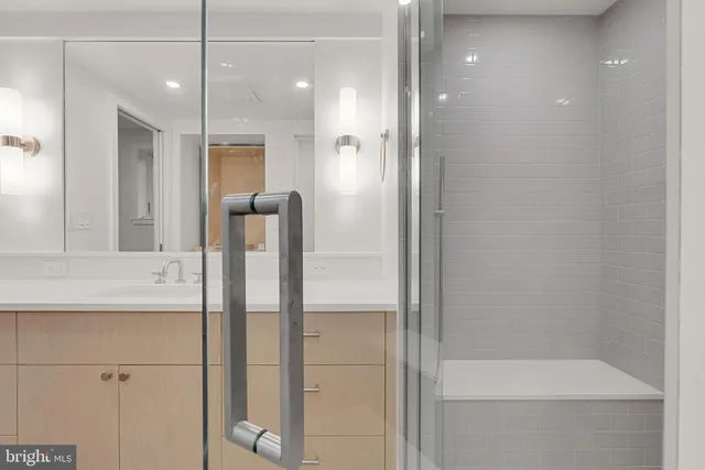 a bathroom with a shower sink and mirror