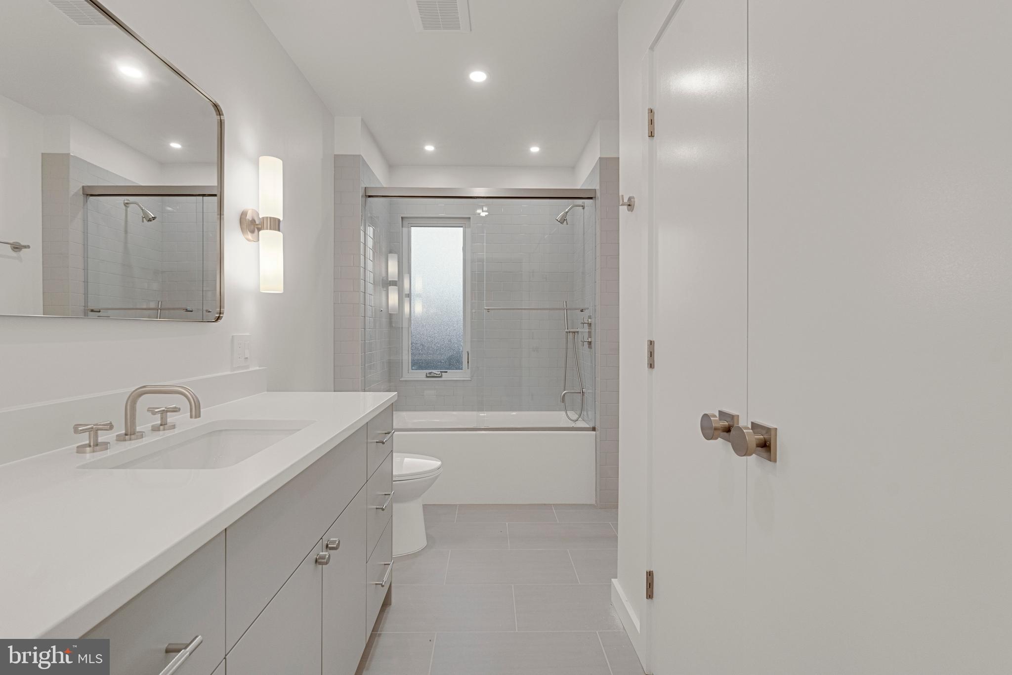 2706 Bartol Avenue Baltimore, MD 21209 - Photo 49 of 62 a bathroom with a shower sink vanity and mirror