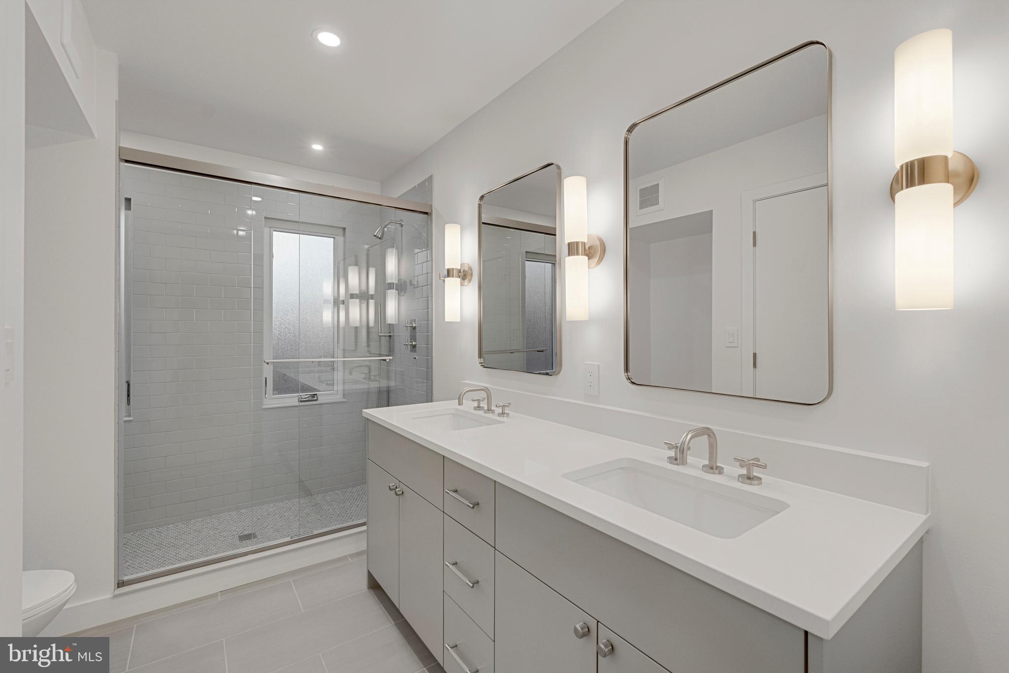 2706 Bartol Avenue Baltimore, MD 21209 - Photo 50 of 62 a bathroom with a shower sink and mirror