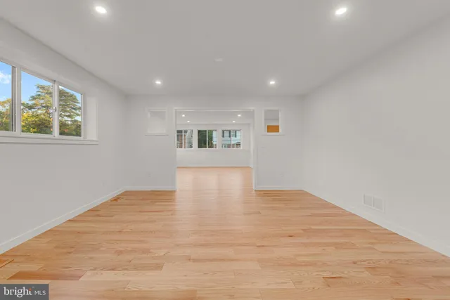 a view of empty room with wooden floor and window