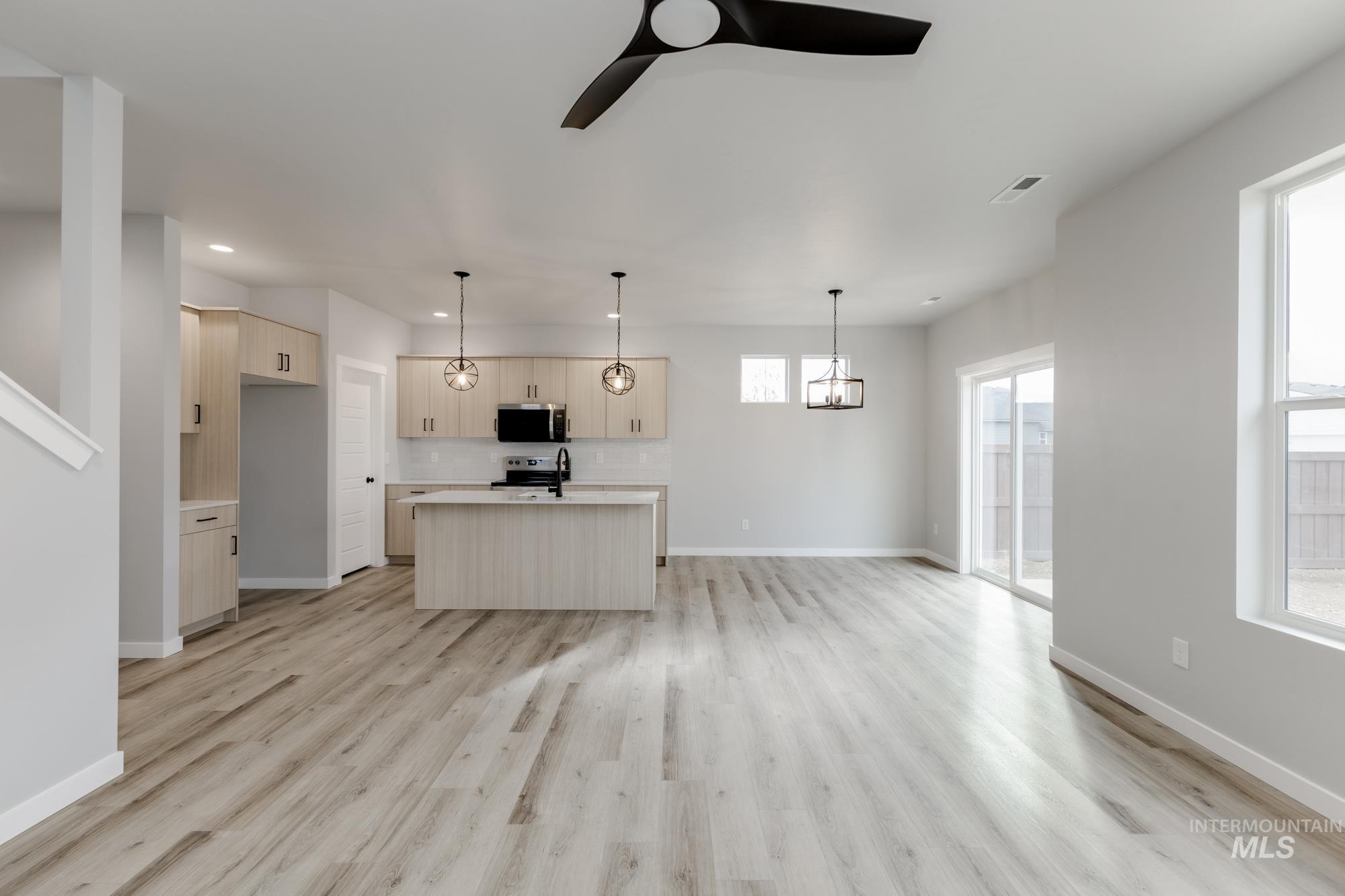 891 North Mirror Creek Way Meridian, ID 83642 - Photo 11 of 20 Unfurnished living room featuring light wood-type flooring, a ceiling fan, and recessed lighting