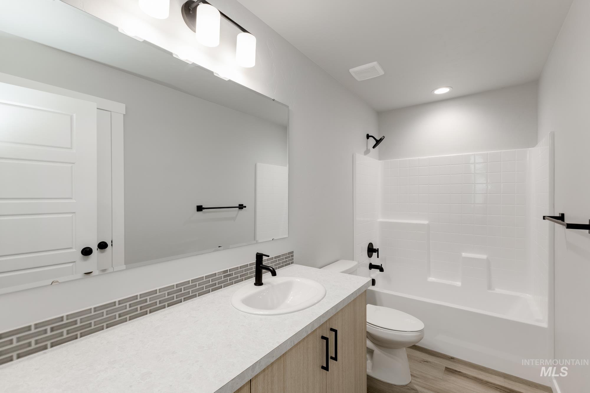 891 North Mirror Creek Way Meridian, ID 83642 - Photo 15 of 20 Full bath featuring vanity, bathtub / shower combination, light wood-style flooring, and recessed lighting