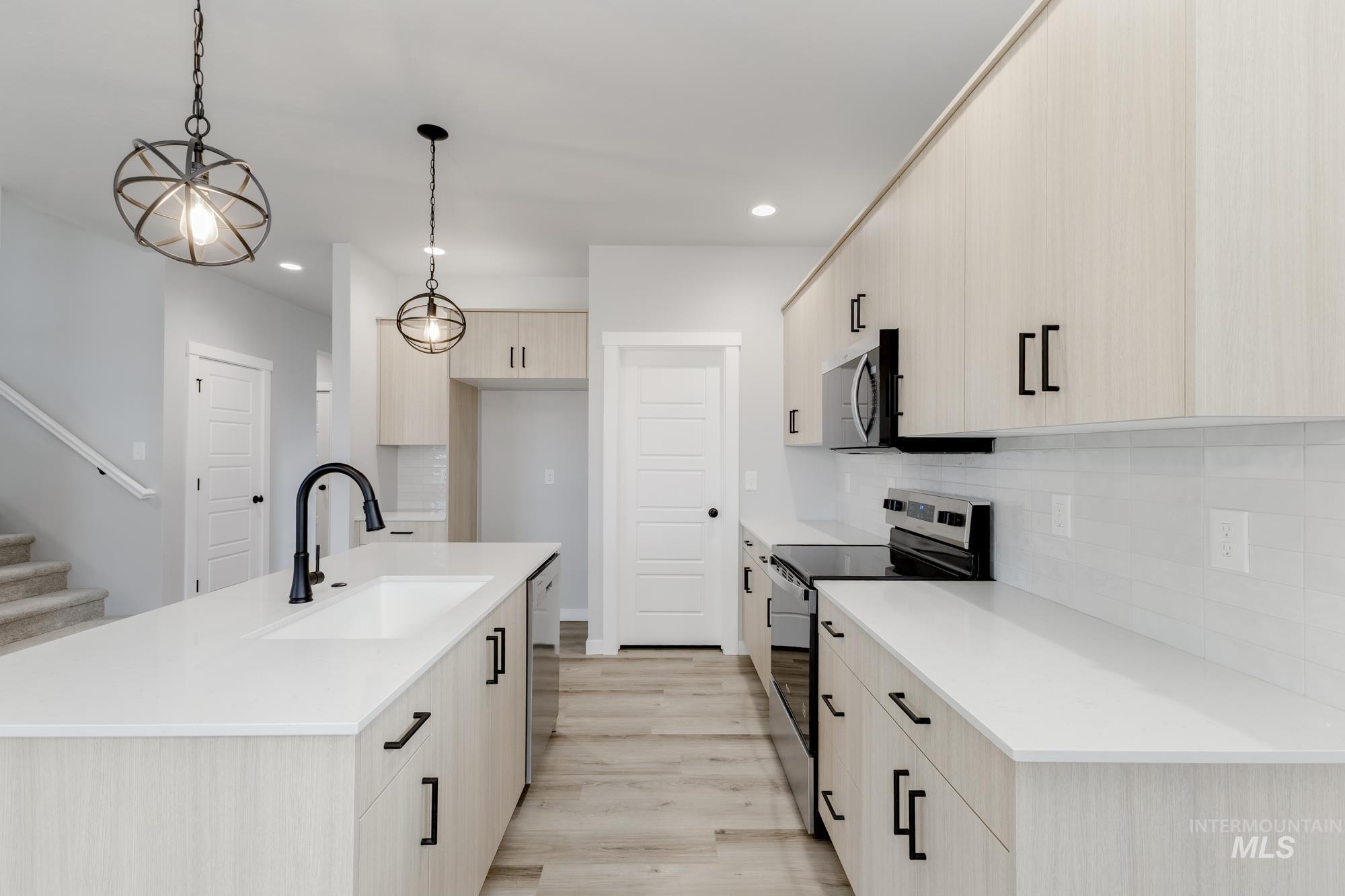 891 North Mirror Creek Way Meridian, ID 83642 - Photo 6 of 20 Kitchen with appliances with stainless steel finishes, light brown cabinets, decorative backsplash, and recessed lighting