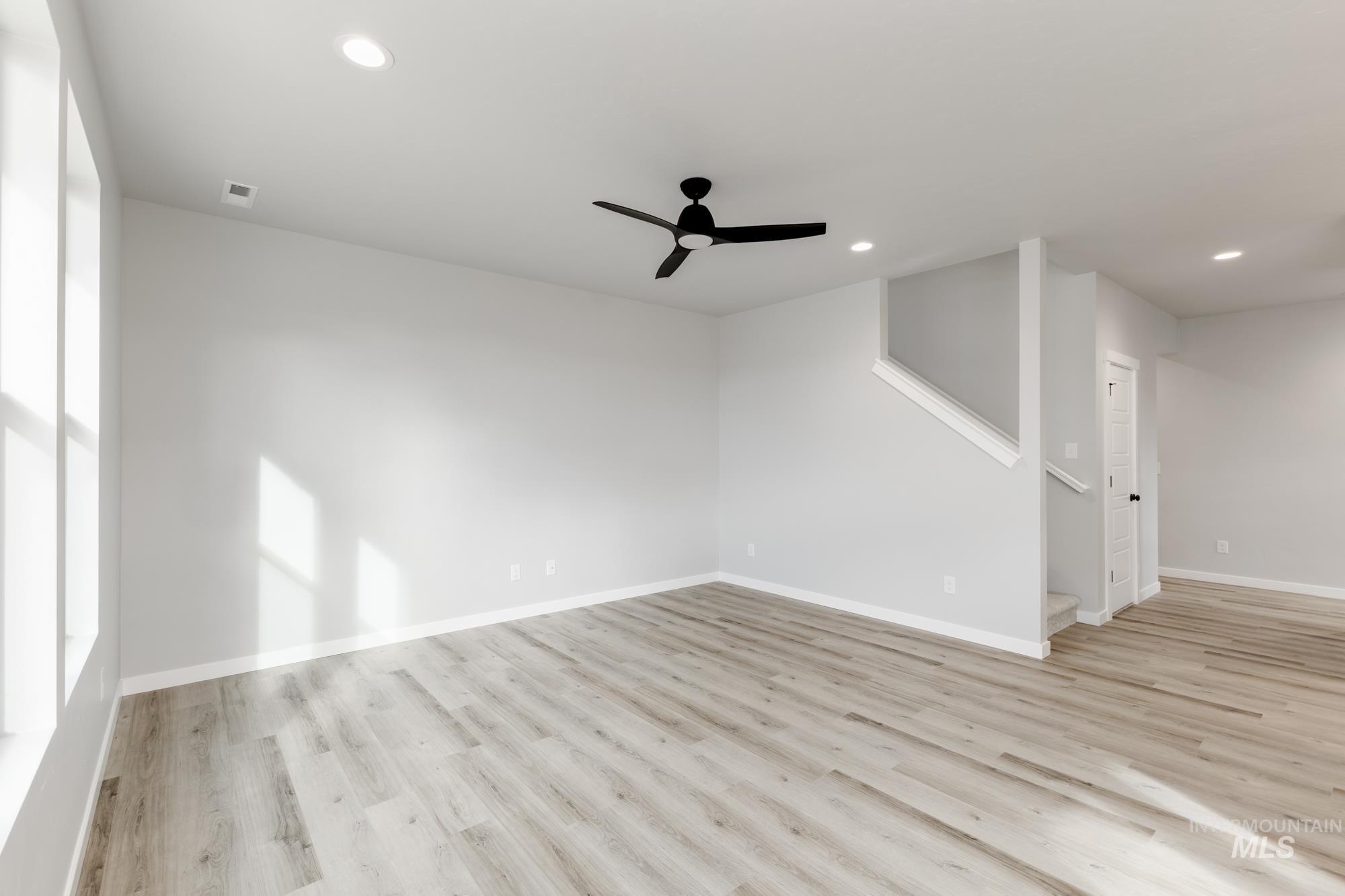 891 North Mirror Creek Way Meridian, ID 83642 - Photo 10 of 20 Empty room featuring light wood-style floors, a ceiling fan, and recessed lighting