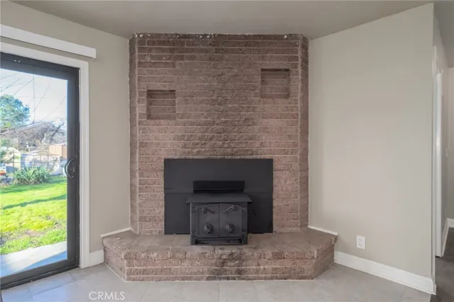 a living room with a fireplace and a floor to ceiling window