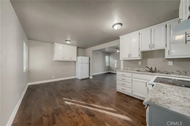 a kitchen with granite countertop white cabinets and white appliances
