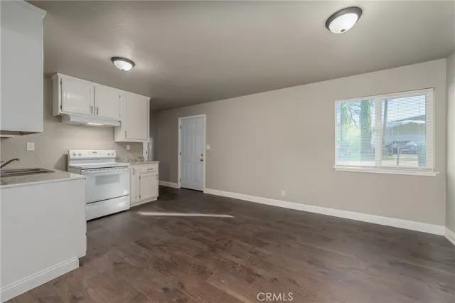 a kitchen with granite countertop white cabinets and white appliances