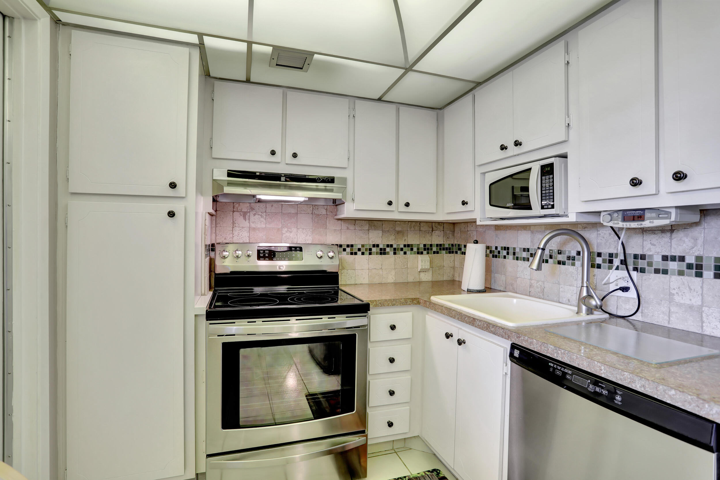 3001 South Course Drive, Unit 508 Pompano Beach, FL 33069 - Photo 5 of 36 a kitchen with granite countertop a sink stove and cabinets