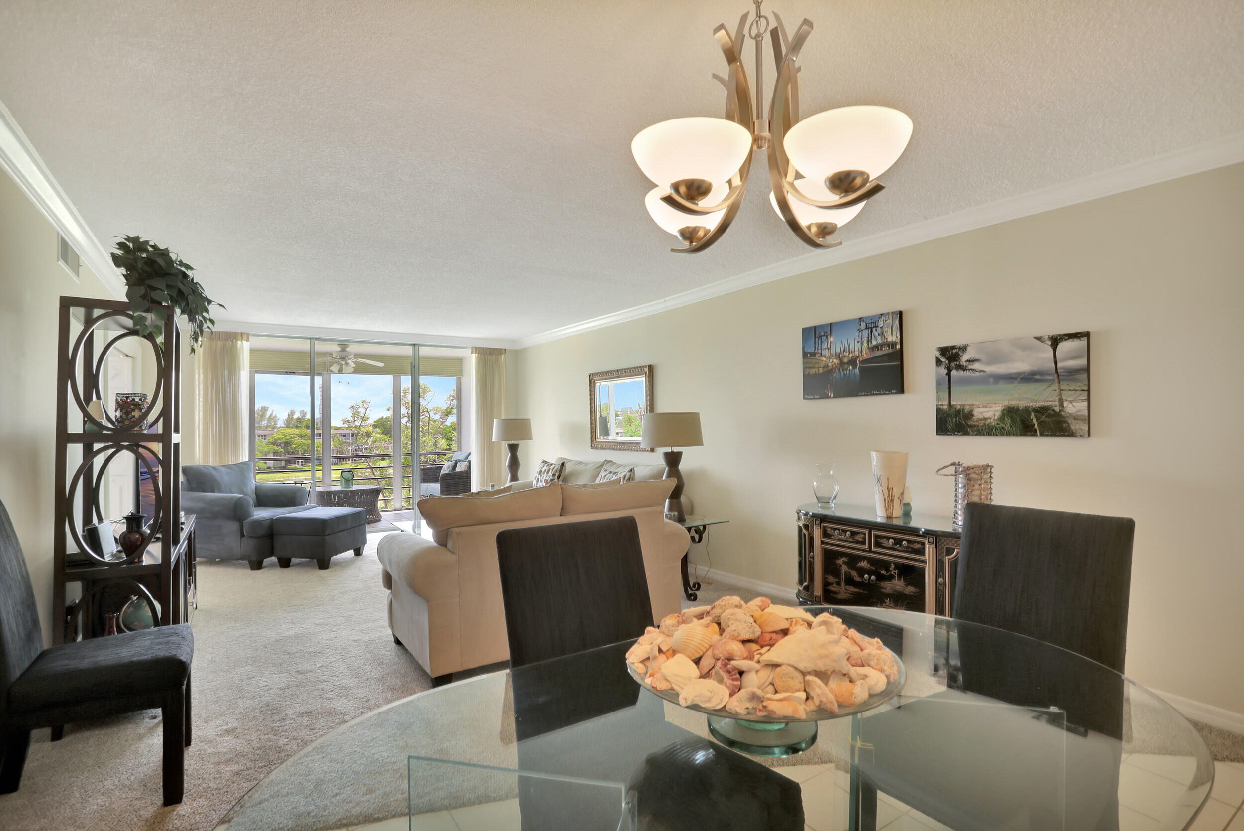 3001 South Course Drive, Unit 508 Pompano Beach, FL 33069 - Photo 8 of 36 a living room with furniture a chandelier and a large window