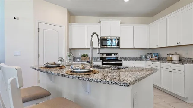 a kitchen with stainless steel appliances granite countertop a sink stove and cabinets
