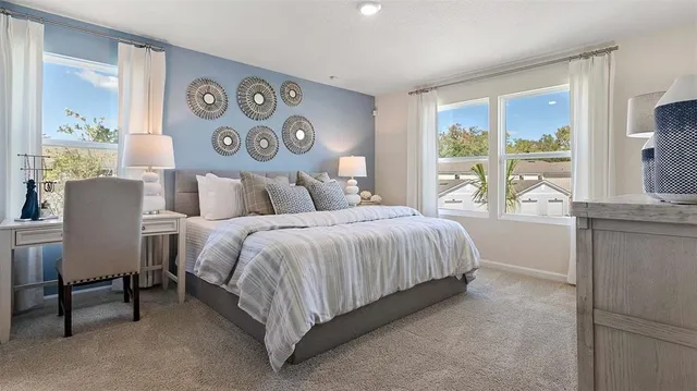 a bedroom with a bed lamp and a large window