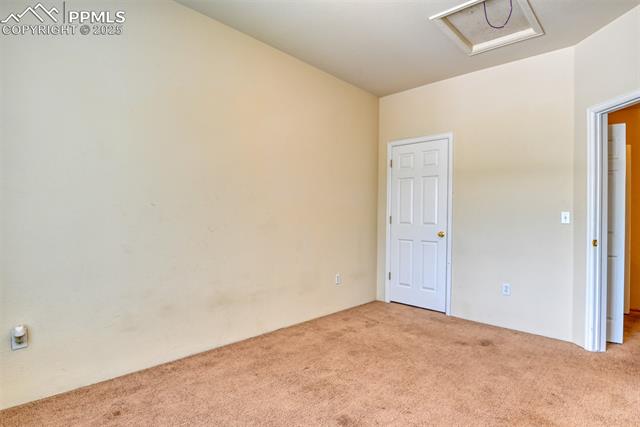 2049 Legacy Ridge View, Unit 111 Colorado Springs, CO 80910 - Photo 21 of 32 Unfurnished room featuring carpet floors and attic access