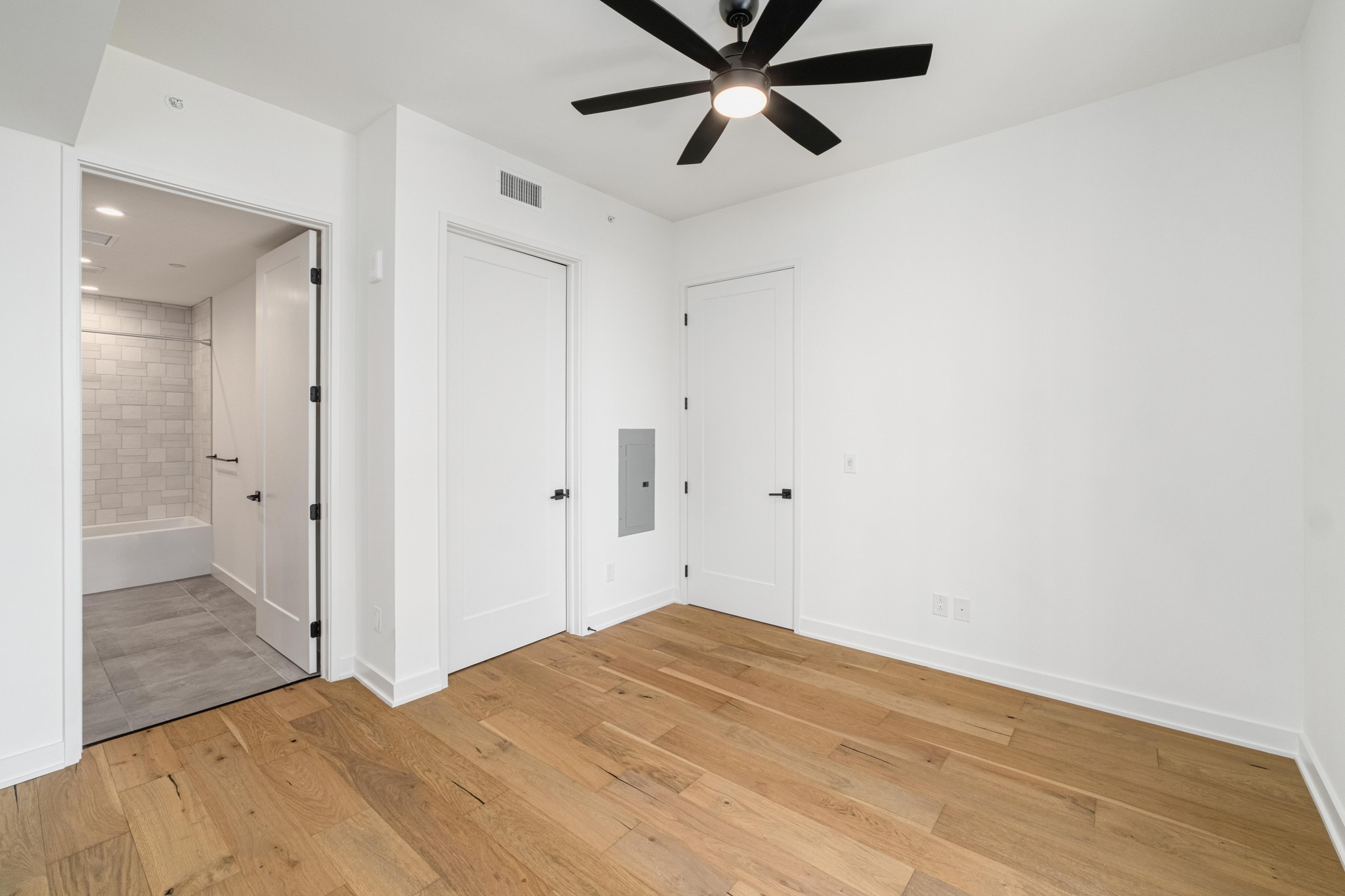 84 East Avenue, Unit 2008 Austin, TX 78701 - Photo 17 of 23 Hardwood floors and a ceiling fan create a comfortable and inviting atmosphere in this versatile space.