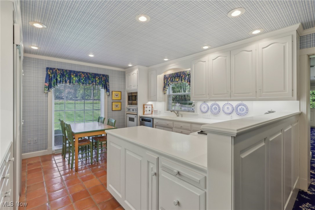 2060 Stockbridge Road Akron, OH 44313 - Photo 14 of 41 Kitchen featuring white cabinetry, kitchen peninsula, stainless steel appliances, crown molding, and sink