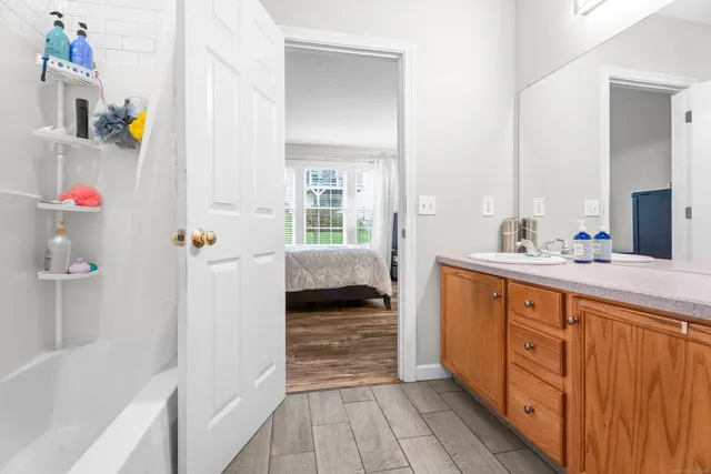 a spacious bathroom with a tub sink and mirror