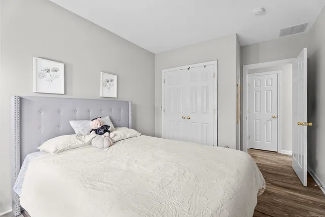 a bedroom with a bed and a wooden floor