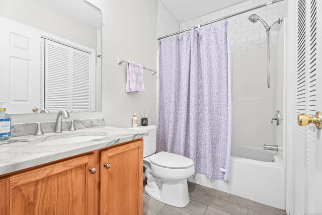 a bathroom with a granite countertop sink toilet and shower