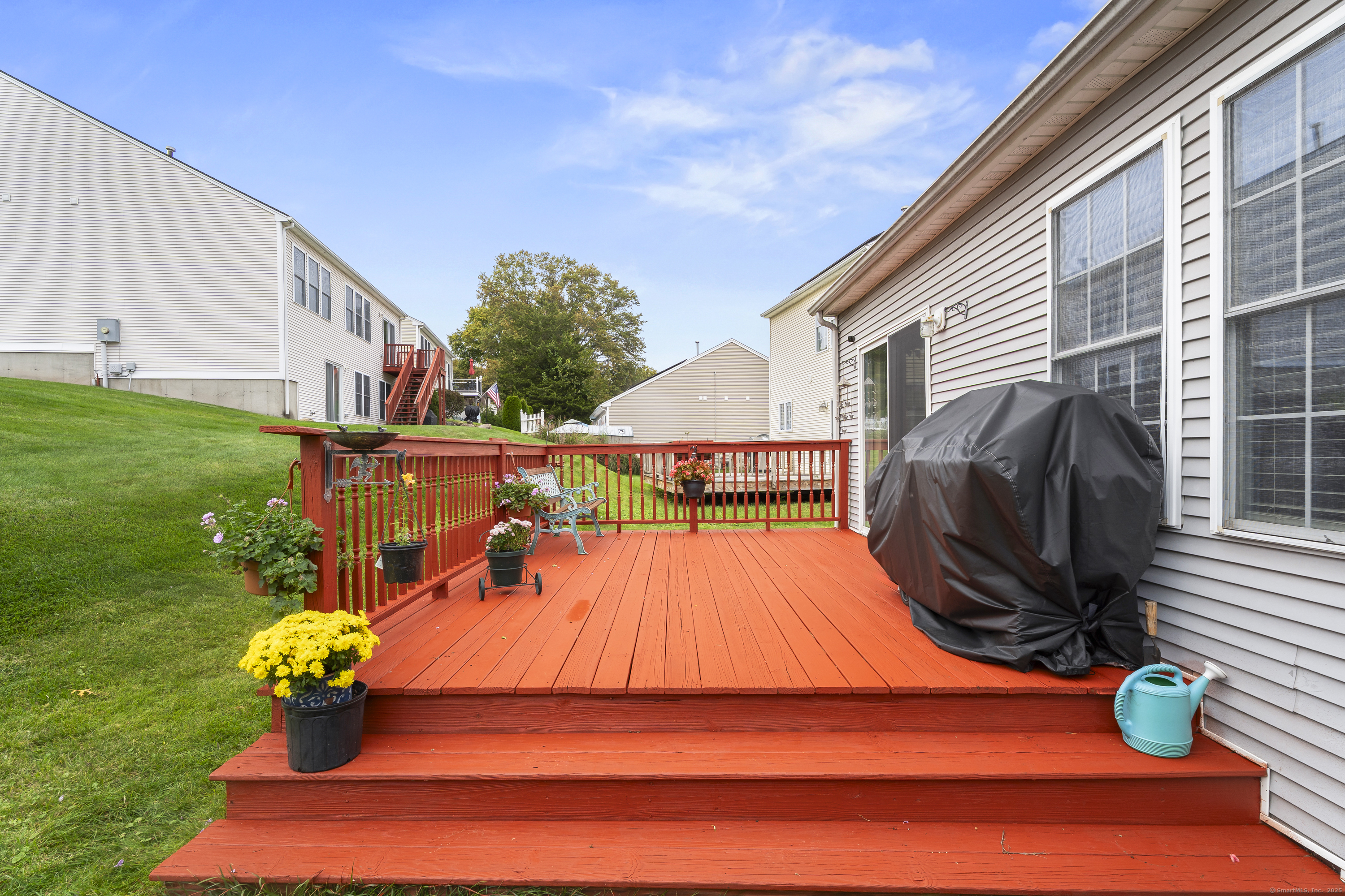 29 Primrose Lane, Unit 29 Suffield, CT 06078 - Photo 27 of 32 a backyard of a house with table and chairs potted plants and a large tree