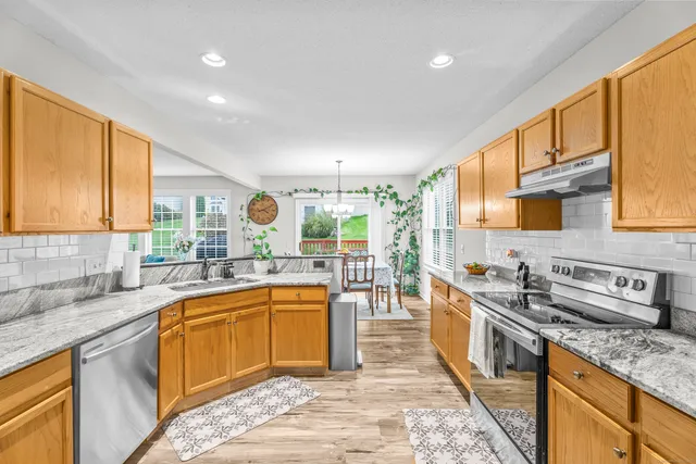 a kitchen with stainless steel appliances granite countertop sink stove and cabinets