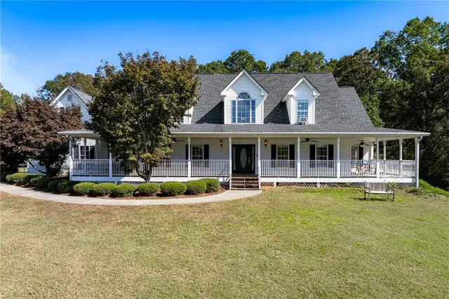 a front view of house with swimming pool and green space