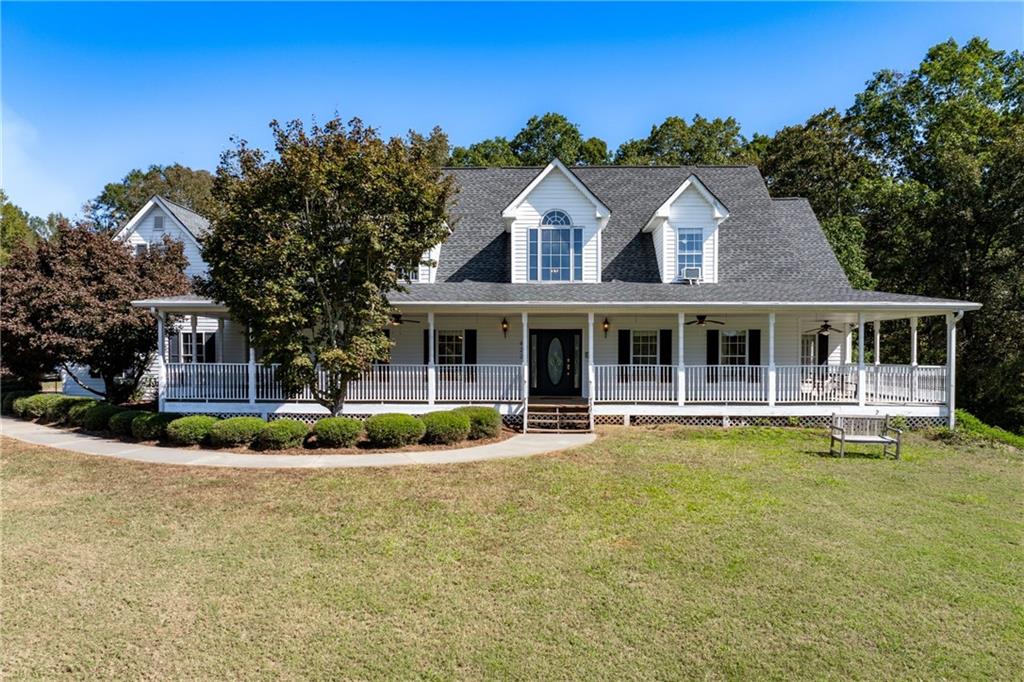 a front view of house with swimming pool and green space