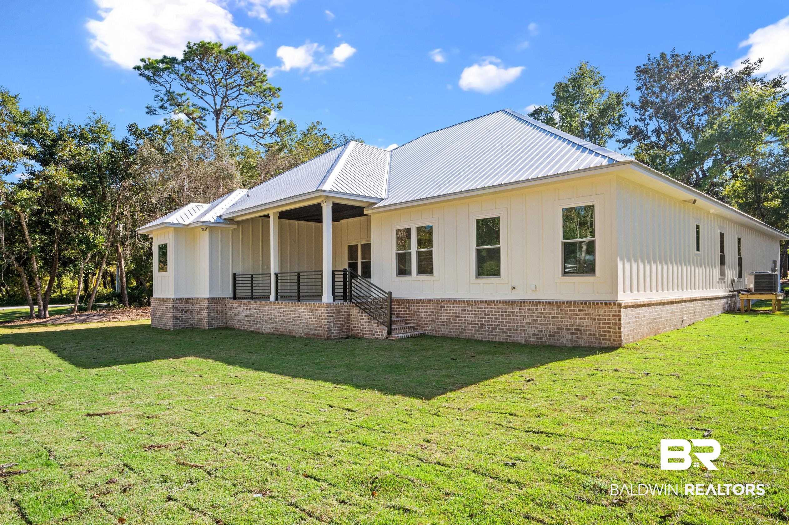 28889 Canal Road Orange Beach, AL 36561 - Photo 48 of 55 Rear view of property with a yard and central AC