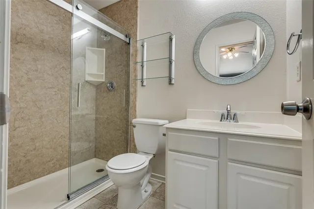 a bathroom with a toilet sink vanity and mirror