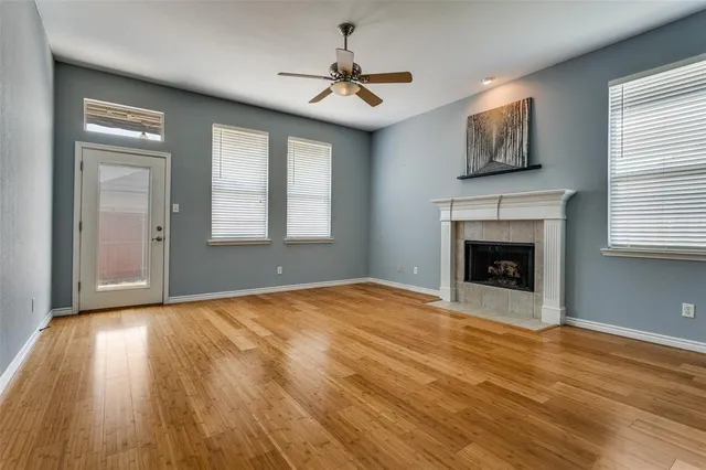 a view of empty room with fireplace and wooden floor
