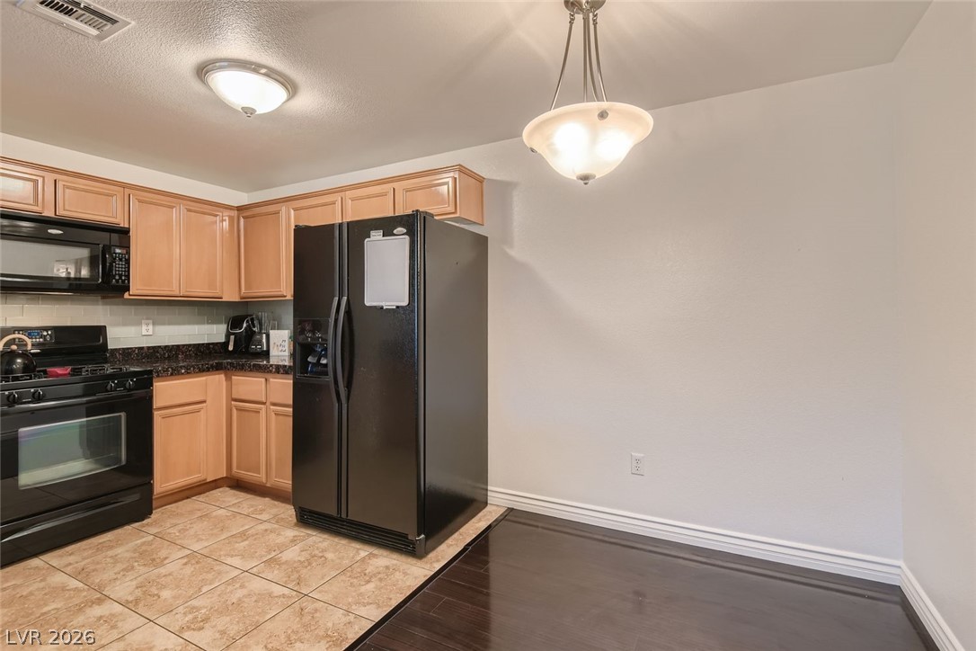 7701 West Robindale Road, Unit 265 Las Vegas, NV 89113 - Photo 9 of 27 Gleaming tile transitions to rich wood flooring in this open culinary and dining space.