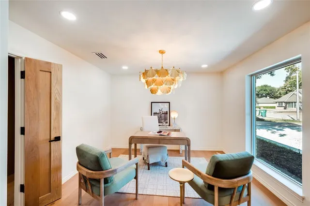 a dining room with furniture a chandelier and wooden floor