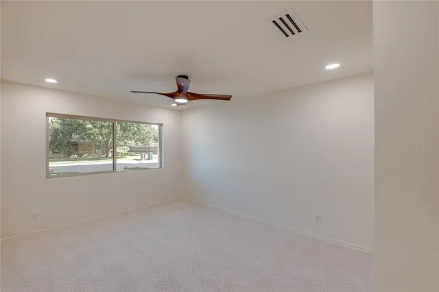 a view of a livingroom with a ceiling fan and window