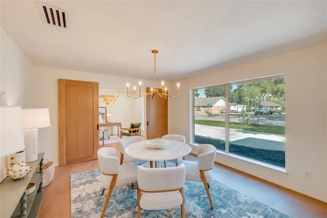 a view of a dining room with furniture a chandelier and wooden floor