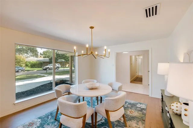 a dining room with furniture a chandelier and wooden floor