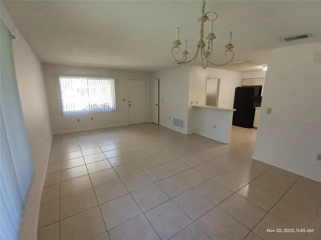 a view of a livingroom with a chandelier furniture and windows