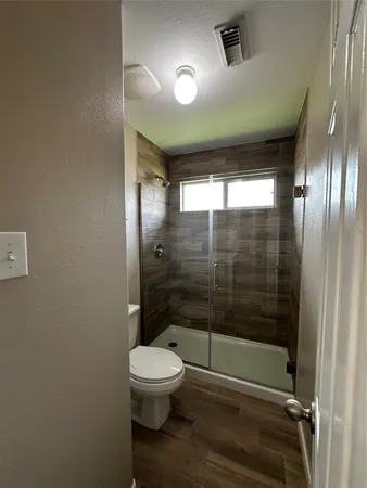 a bathroom with a toilet and a shower