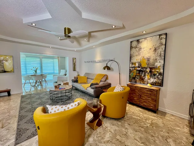 a living room with furniture a flat screen tv and a large window