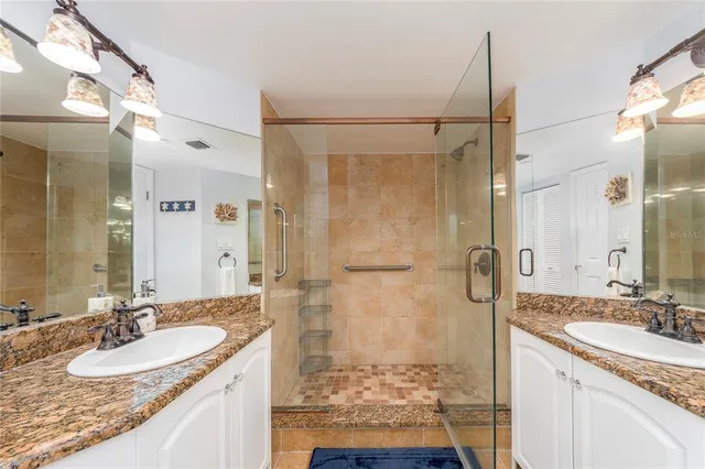 a bathroom with a granite countertop sink mirror and shower