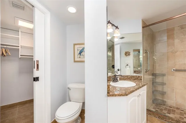 a bathroom with a granite countertop sink toilet a mirror and shower