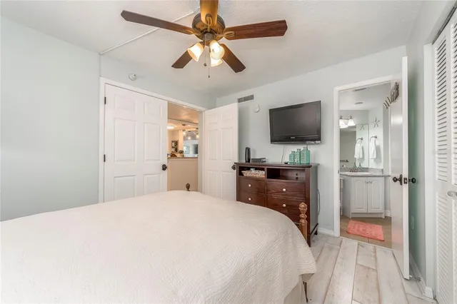 a bedroom with a bed and a flat tv screen on dresser