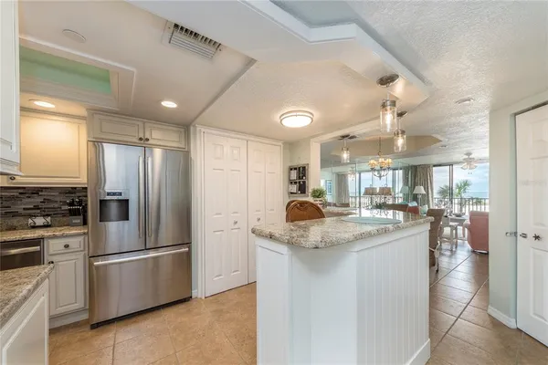 a kitchen with stainless steel appliances granite countertop a sink a stove and a refrigerator