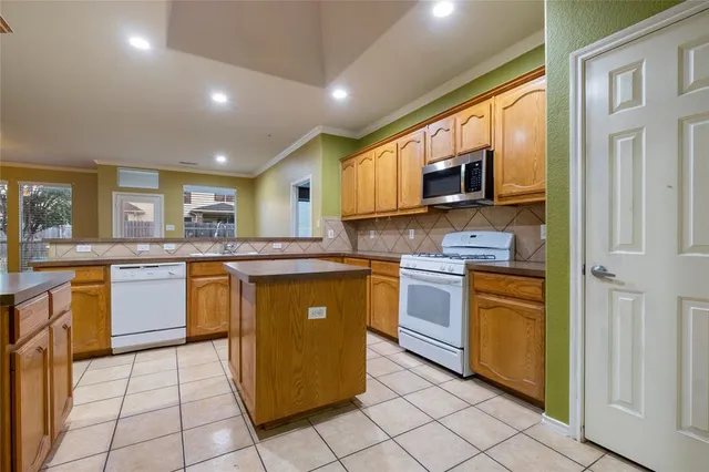 a kitchen with stainless steel appliances granite countertop a stove top oven a sink a counter top space and cabinets
