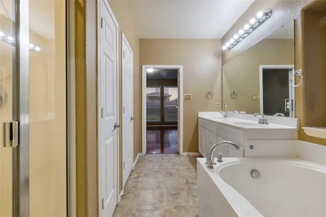 a spacious bathroom with a tub sink and mirror
