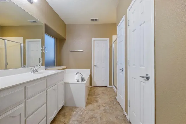 a spacious bathroom with a double vanity sink a mirror and a shower