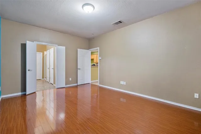 a view of an empty room with wooden floor