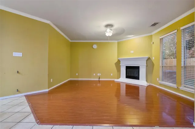 a view of empty room with wooden floor and fireplace